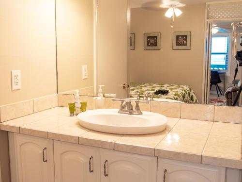 a bathroom counter with a sink and a mirror at Chateau 6W Alluring Beachfront Condo in Clearwater Beach