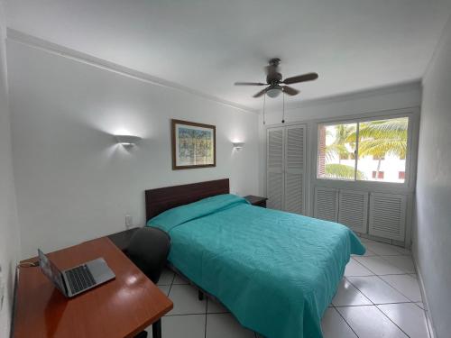 a bedroom with a bed and a desk and a window at Casa Blanca: Frente al mar in Same