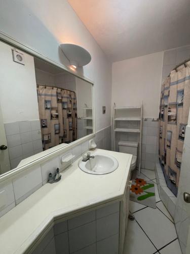 a bathroom with a sink and a large mirror at Casa Blanca: Frente al mar in Same