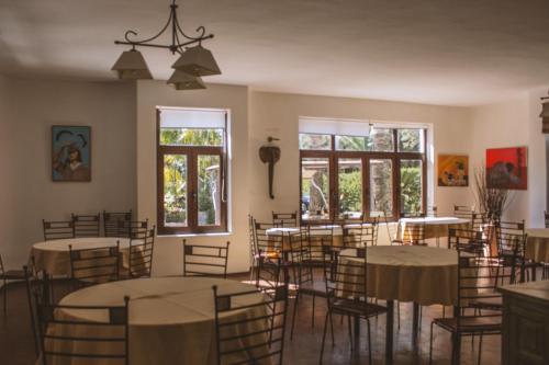 a dining room with tables and chairs and windows at TAIGA Tarifa in Tarifa