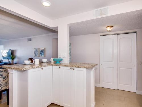 a kitchen with white cabinets and a white door at Harbour Light Towers 307 3rd Floor Beachfront 2 Bedroom Harbour Light Towers in Clearwater Beach