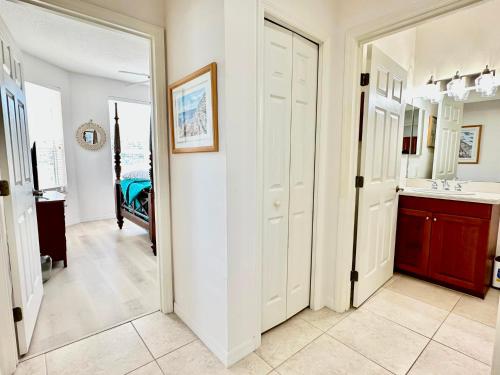 a hallway with a bathroom with a sink and a mirror at Island Key 305 - Amazing Waterfront Condo - Walk to the Beach in Clearwater Beach