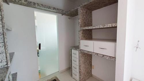 een badkamer met witte planken en een glazen deur bij Férias na Bahia e a 200m da praia in Porto Seguro