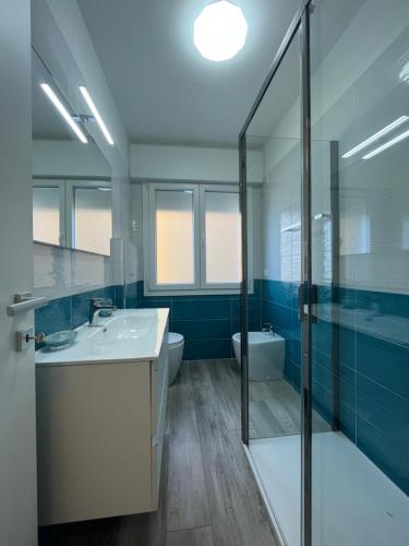 ein Badezimmer mit Waschbecken, Dusche und Toilette in der Unterkunft Scaramuzza 7 in Grado
