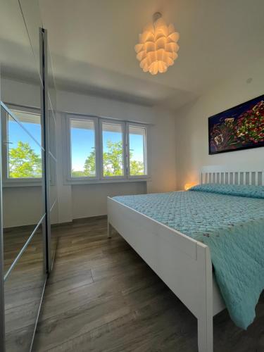 ein Schlafzimmer mit einem Bett und einem Kronleuchter in der Unterkunft Scaramuzza 7 in Grado