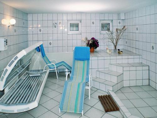 a bathroom with a slide and a bench and a tub at Hotel Fürstenberg in Eisenhüttenstadt