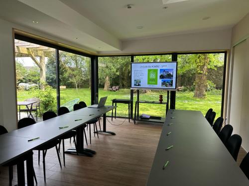 a row of tables and chairs in a room with a screen at Le Clos Du Pontic Logis et Cit'Hotel in Landerneau