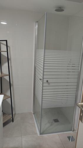 een douchecabine met een glazen deur in de badkamer bij Yona balev in Eilat