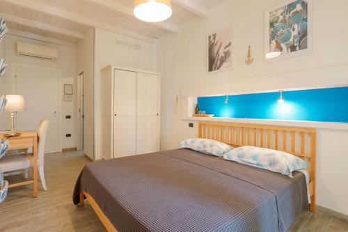 una camera con un letto con una parete blu di Il Cagliarese B&B a Cagliari