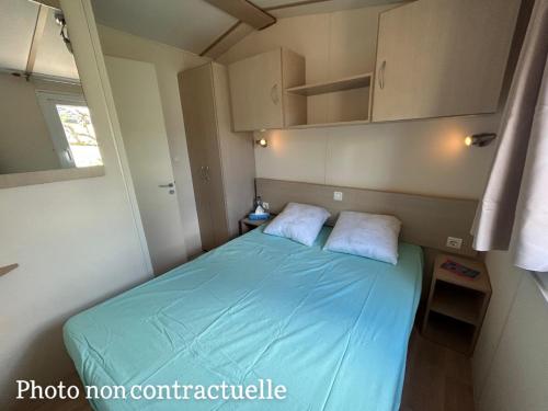 1 dormitorio pequeño con 1 cama en una habitación pequeña en Les mobil homes de NOLY Draps inclus ,TV ,Clim en Port-la-Nouvelle