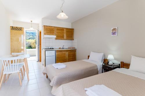 um quarto de hotel com duas camas e uma cozinha em O Molos em Marmari