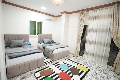 a bedroom with two beds and a rug at Typique appartement avec vue sur la Mer Rouge in Quseir