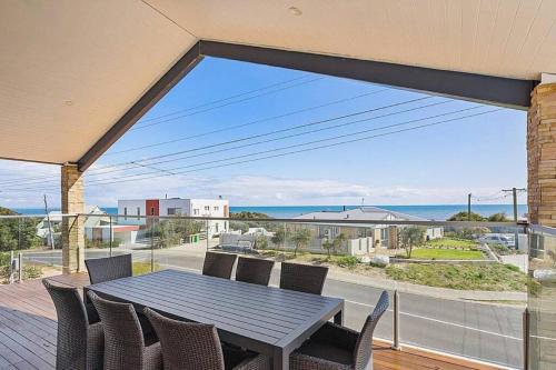 a table and chairs on a balcony with a view of the ocean at Seascape Beach House in Capel
