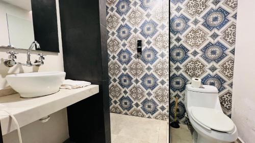 a bathroom with a white toilet and a sink at Hotel MAYARI Holbox in Holbox Island