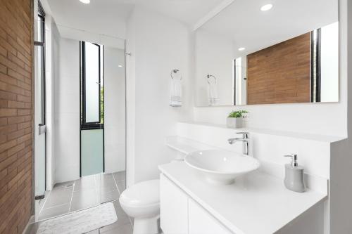 Baño blanco con lavabo y aseo en Súper apartamento en Laureles, en Medellín