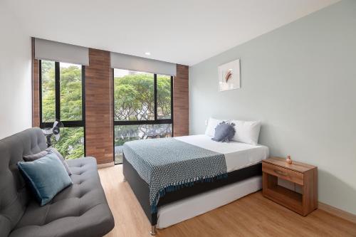 a bedroom with a bed and a couch at Súper apartamento en Laureles in Medellín