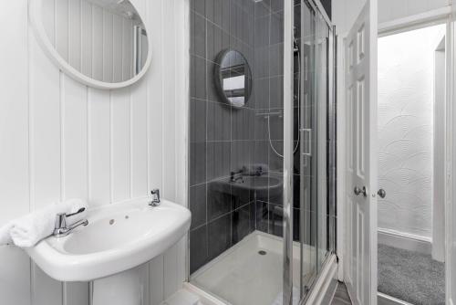a white bathroom with a sink and a shower at Host Liverpool - Anfield's Comfy Corner, Stylish & Fam-Friendly in Liverpool
