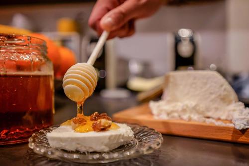 a person is spooning honey on top of a dessert at Il Cagliarese B&B in Cagliari