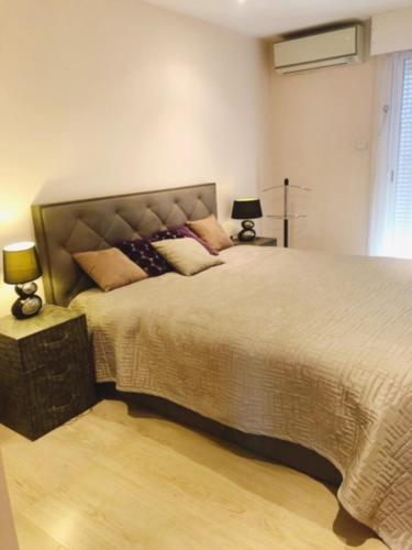 Luxurious appartment near the airport Nice في نيس: غرفة نوم بسرير كبير عليها مخدات
