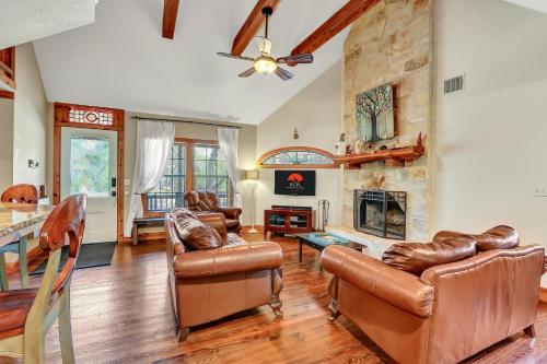 a living room with leather furniture and a stone fireplace at The Cabin at Rooster Ridge in Fischer