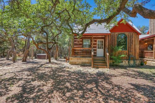 a log cabin with a porch and a tree at The Cabin at Rooster Ridge in Fischer