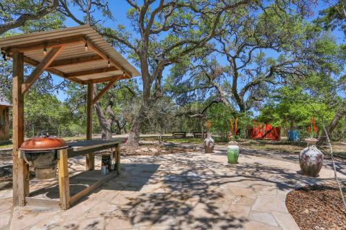 a pavilion with a grill and vases in a park at The Cabin at Rooster Ridge in Fischer