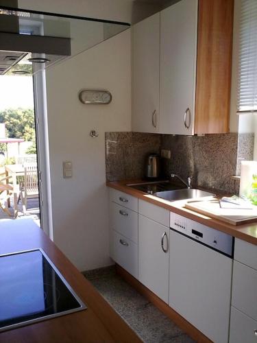 a kitchen with white cabinets and a sink at Ferienhaus Ostseeblick in Wohlenberg