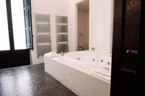 baño blanco con bañera y ventana en Delta Apartments, en Bari