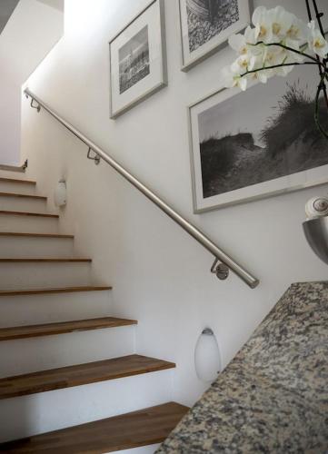a staircase with white walls and a stair railing at Ferienhaus Ostseeblick in Wohlenberg