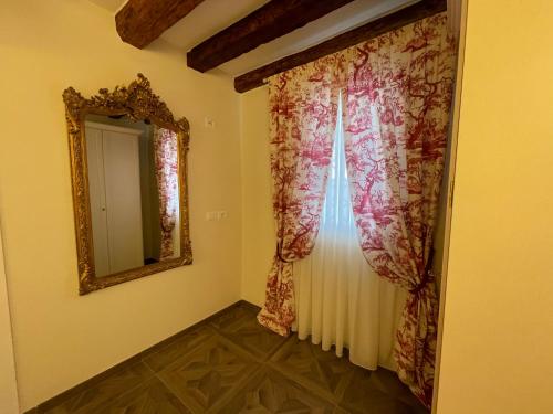 een kamer met een spiegel, een gordijn en een raam bij MH2665 in Venetië