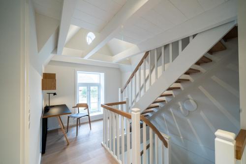 a white staircase in a house with a desk at Frigga in Nieblum