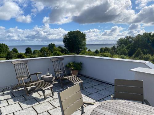 a patio with chairs and a view of the ocean at Ferienhaus Ostseeblick in Wohlenberg