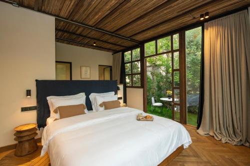 a bedroom with a large white bed and large windows at To Be Social House in Fethiye