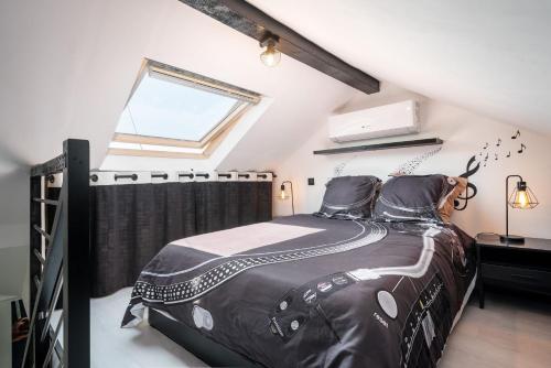 a bedroom with a bed with a black comforter and a window at Life is music - Casa Vostra - Gaillard proche tramway-frontière in Gaillard