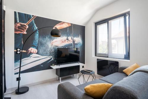 ein Wohnzimmer mit einem Sofa und einem TV in der Unterkunft Life is music - Casa Vostra - Gaillard proche tramway-frontière in Gaillard