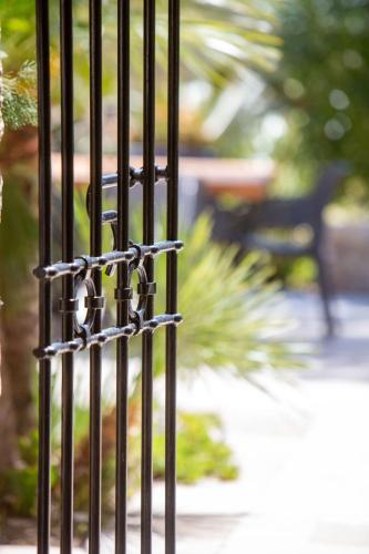 a black iron fence with a bench in the background at Domaine du Reginu in Santa-Reparata-di-Balagna