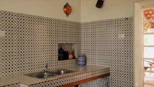 uma cozinha com um lavatório e uma parede em azulejo em MareDentro em Mazara del Vallo