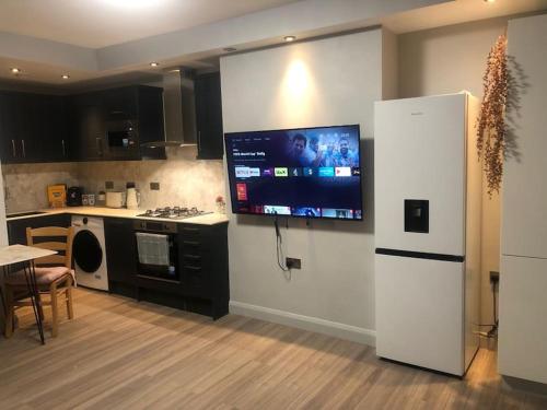 a kitchen with a flat screen tv on the wall at Royal Mile Famous Canongate Flat in Edinburgh