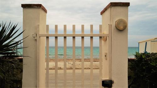a white gate in front of the beach at MareDentro in Mazara del Vallo