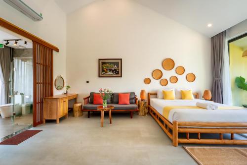 a hotel room with two beds and a bathroom at Saca Townhouse by Class6 in Hoi An