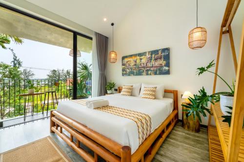 a bedroom with a bed and a large window at Saca Townhouse by Class6 in Hoi An