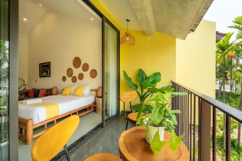 a bedroom with a bed and a balcony at Saca Townhouse by Class6 in Hoi An