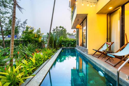 a swimming pool in the backyard of a villa at Saca Townhouse by Class6 in Hoi An