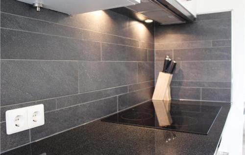 une salle de bains carrelée de noir avec un bloc de couteau sur le mur. dans l'établissement Buitengoed Het Lageveld, à Hoge-Hexel