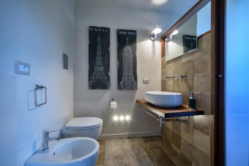 a bathroom with a sink and a toilet and a mirror at Appartamenti con vista - Pomelia in Scicli