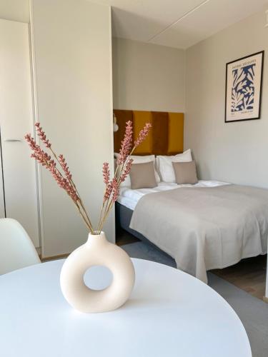 una camera con due letti e un vaso con fiori di Studio Apartment Station a Oulu