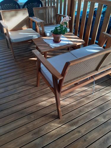 una terraza de madera con mesas y sillas. en les cigales, en Vic-la-Gardiole