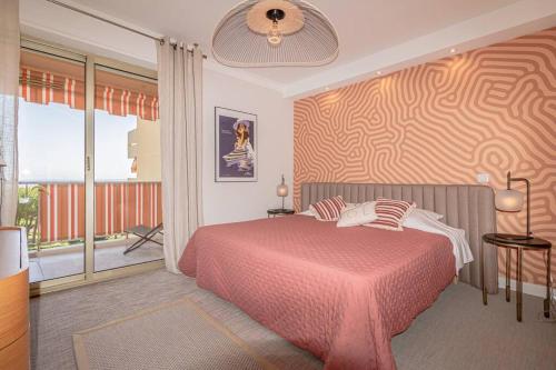 une chambre avec un lit et une grande fenêtre dans l'établissement Superbe appart VUE MER, PLAGE, PISCINE, TENNIS, parking, à Antibes