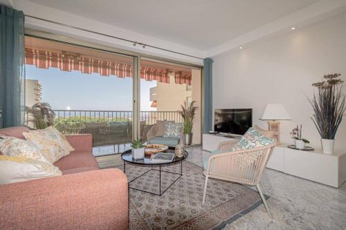 salon z kanapą, krzesłami i telewizorem w obiekcie Superbe appart VUE MER, PLAGE, PISCINE, TENNIS, parking w mieście Antibes