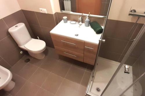a bathroom with a toilet and a sink and a shower at APARTAMENTO PLAYA FOZ in Foz
